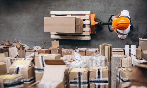 Young man working at a warehouse with boxes