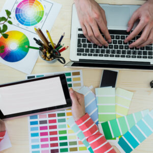 Hands of graphic designers using laptop and digital tablet in office